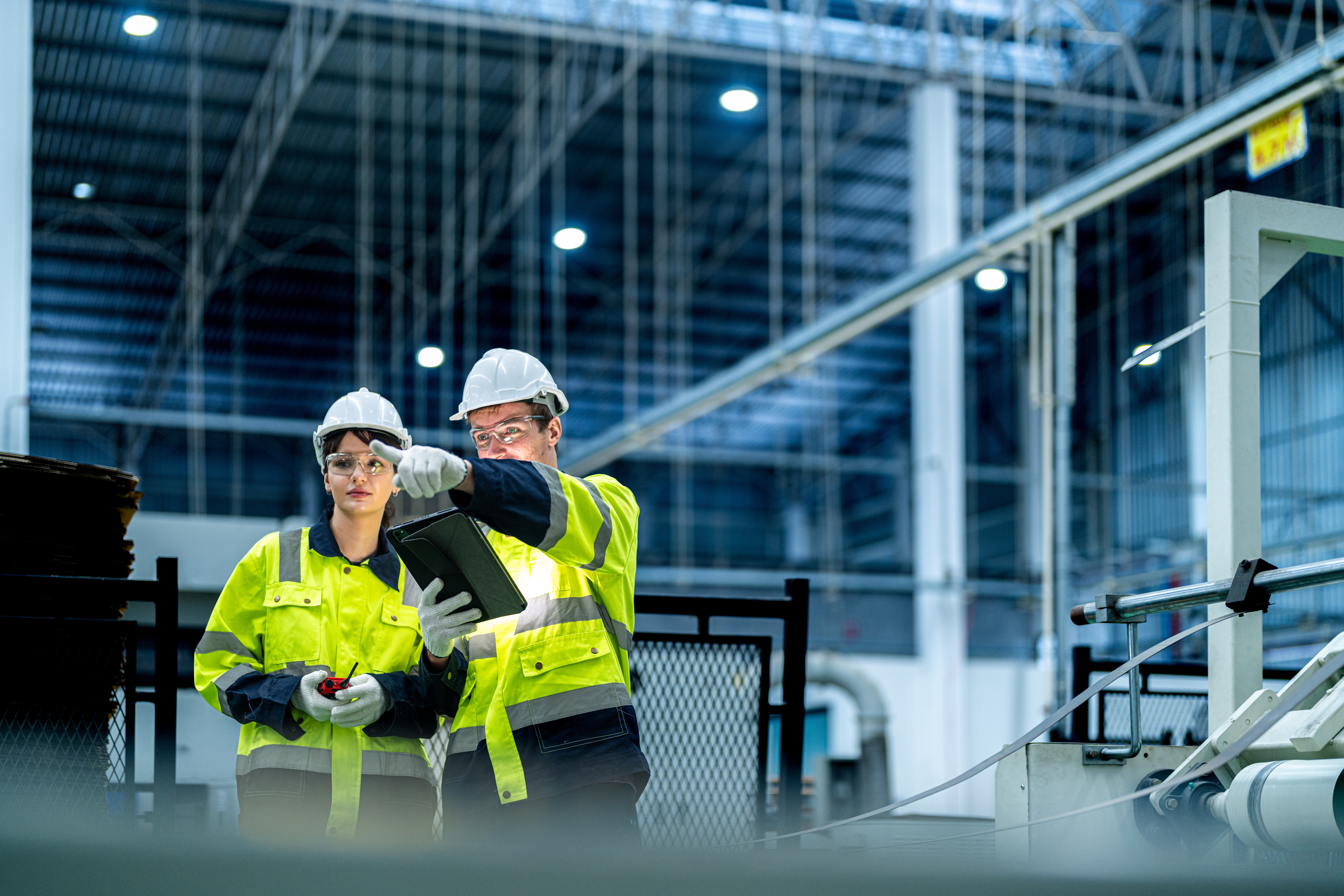 Workers reviewing production data on an industrial factory floor